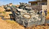 A Stryker is stuck in mud surrounding a stream of sewage in a poor NE Mosul neighborhood.jpg